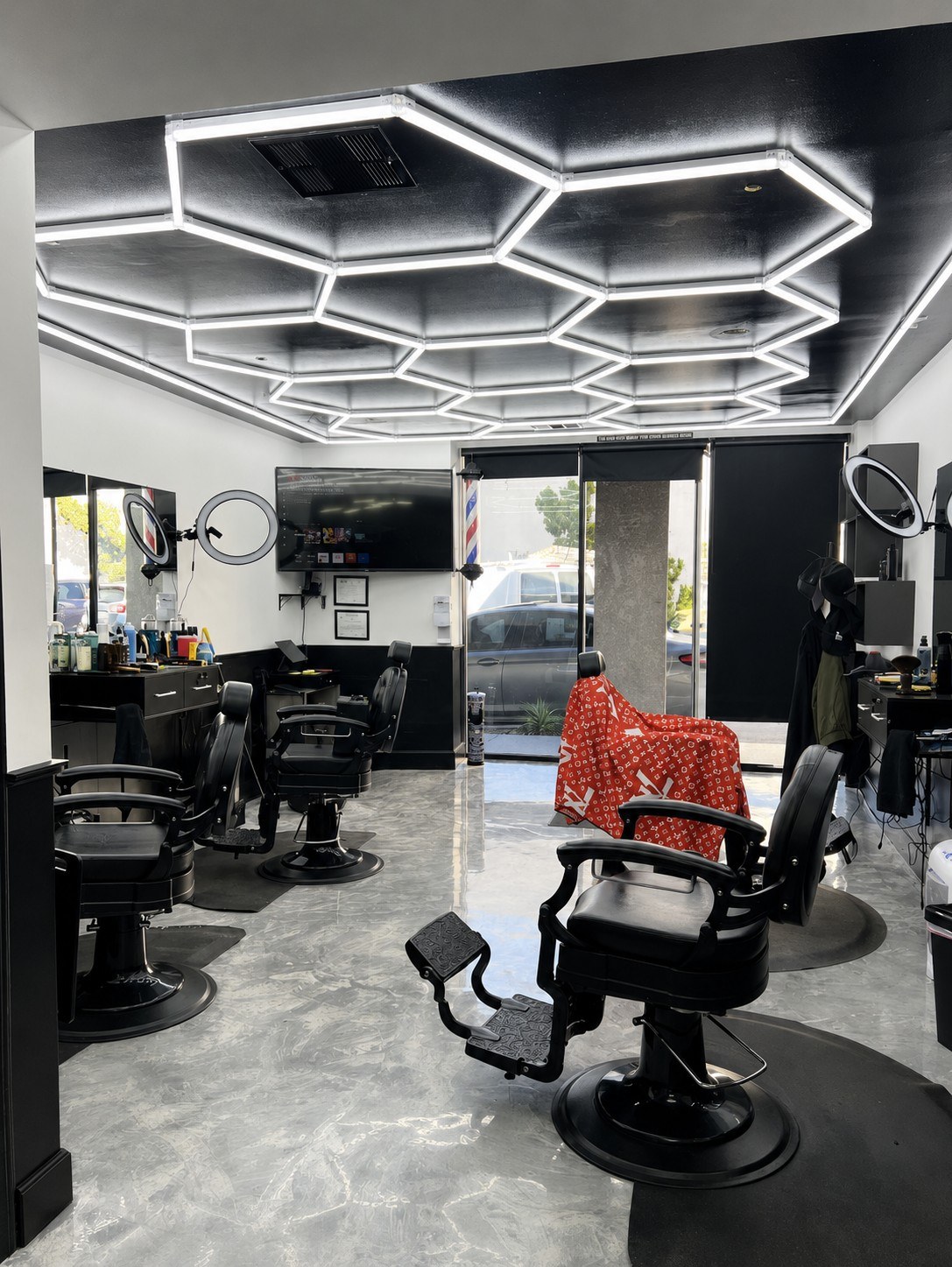 Inside Jojo's Barber Lounge — vintage chrome chairs under the signature hexagonal LED ceiling