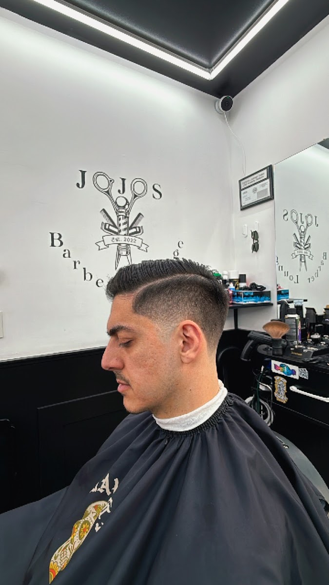 A fresh fade in front of the Jojo's est. 2022 wall mark