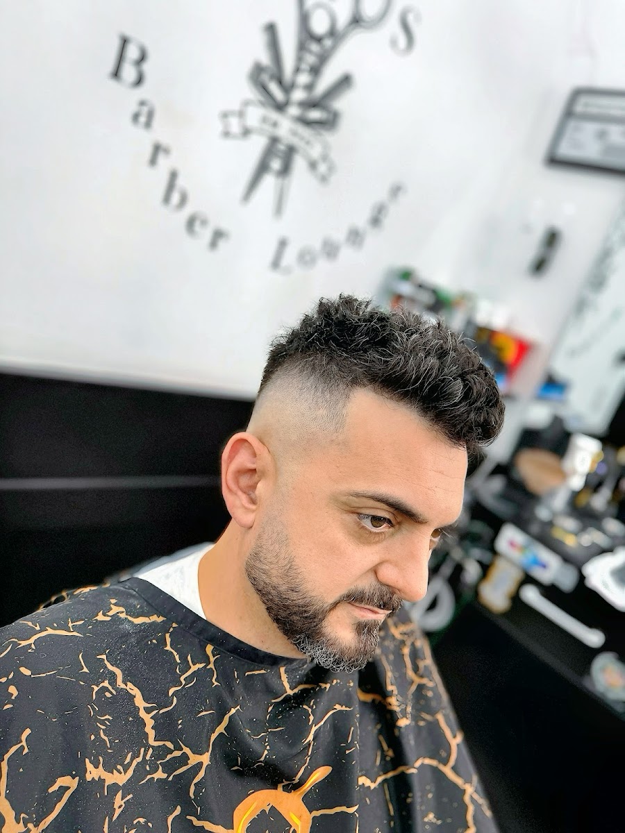 Curly-hair shape-up in front of the Jojo's Barber Lounge logo