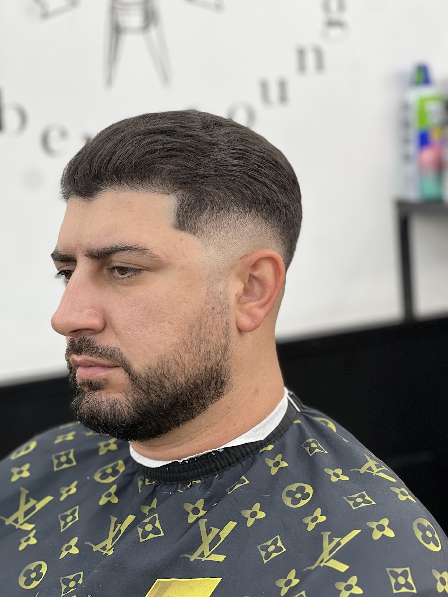 Profile portrait of a clean fade with the Barber Lounge wordmark behind
