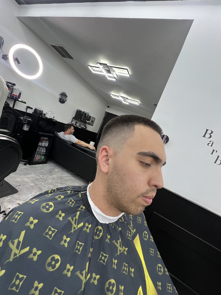 A clean cut in progress with a barber working in the background