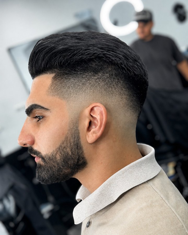 Slicked-back style with low fade and full beard