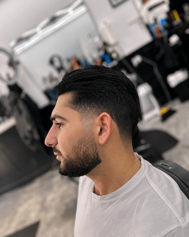 Classic side-part with low fade and trimmed beard